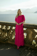 Model wearing a fuchsia Samara Dress, an asymmetric long evening gown with cape detail.